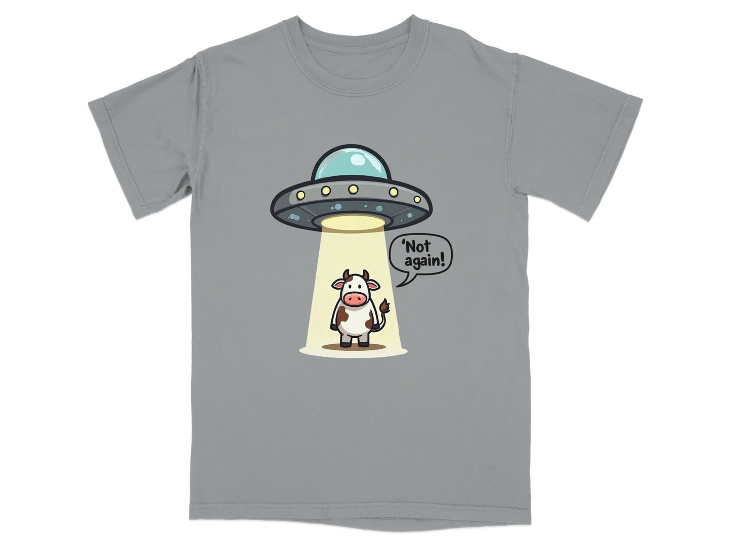Funny alien abduction graphic T-shirt featuring a cow saying 'Not again!' on a gray background.