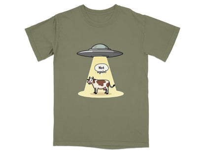 Funny T-shirt design of a cow being abducted by aliens with a 'Not again!' speech bubble.