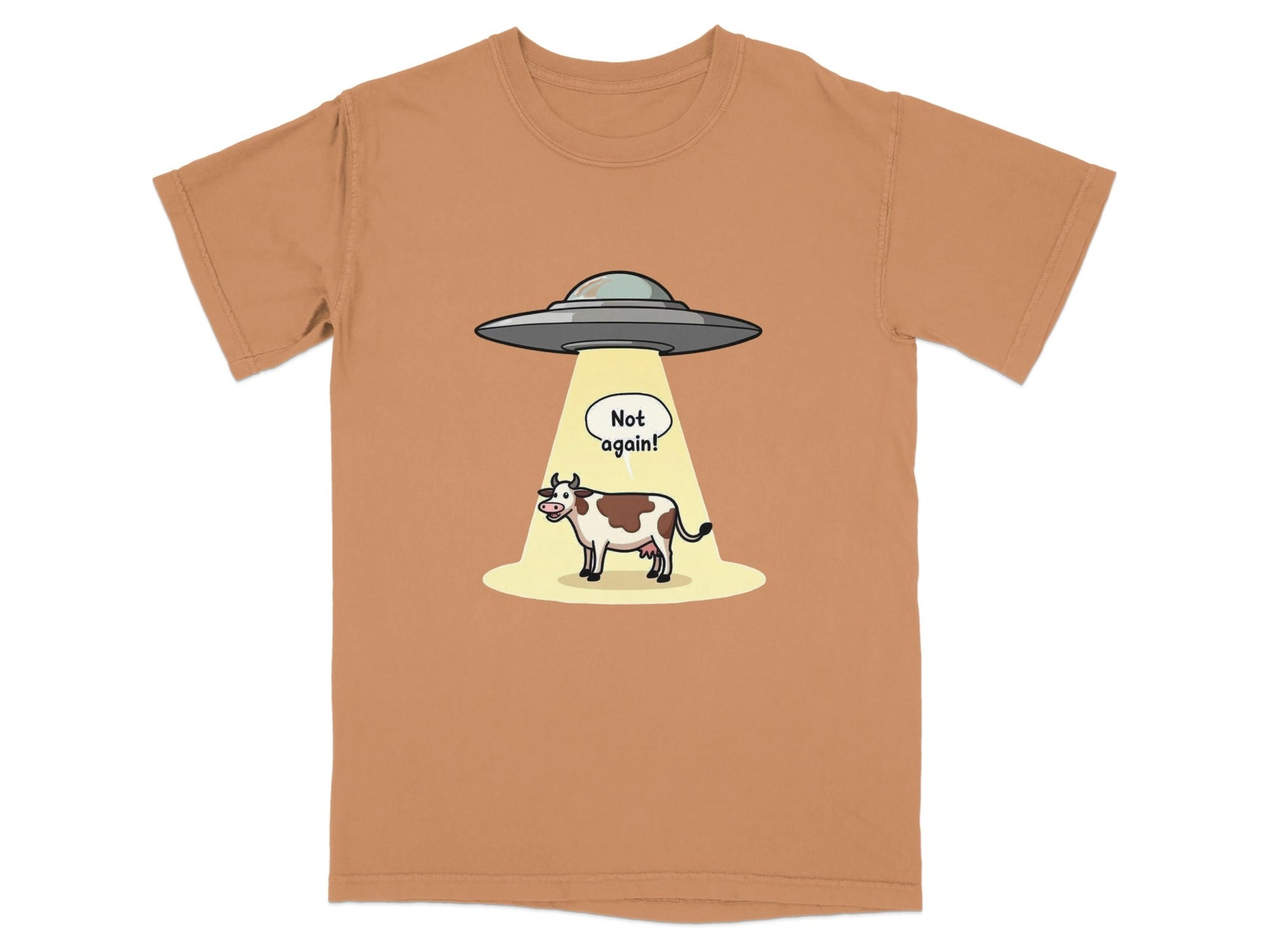 Funny alien abduction t-shirt featuring a cow with a speech bubble saying 'Not again!' on a relaxed fit fabric.