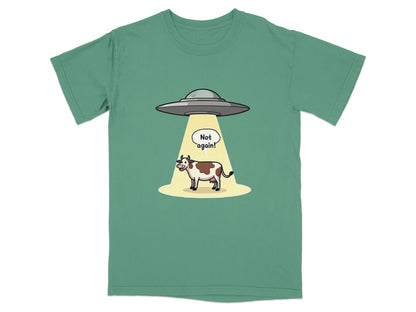 Cartoon t-shirt design featuring a cow being abducted by aliens with 'Not again!' speech bubble