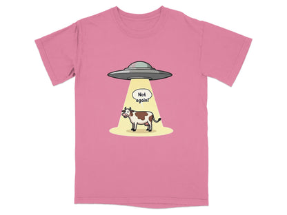 Funny t-shirt design featuring a cow being abducted by aliens with 'Not Again!' speech bubble.