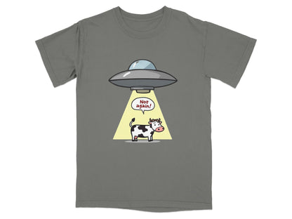Funny cartoon t-shirt featuring a cow being abducted by a UFO with the text 'Not Again!'. Perfect for alien humor fans.