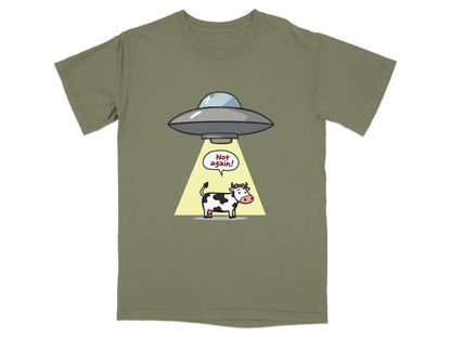Funny cartoon cow abduction graphic on an olive green t-shirt, captioned 'Not again!' for sci-fi fans.